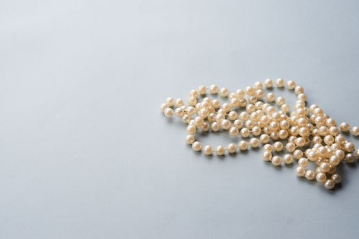 Pearl beads on a gray background decoration decoration top view. High quality photo