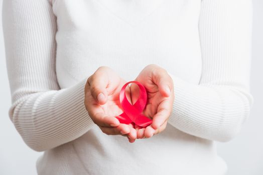 Breast cancer awareness healthcare and medicine concept. Close up Asian woman holding pink breast cancer awareness ribbon on hands treatment charity, studio shot isolated on white background