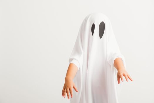 Funny Halloween Kid Concept, little cute child with white dressed costume halloween ghost scary, studio shot isolated on white background