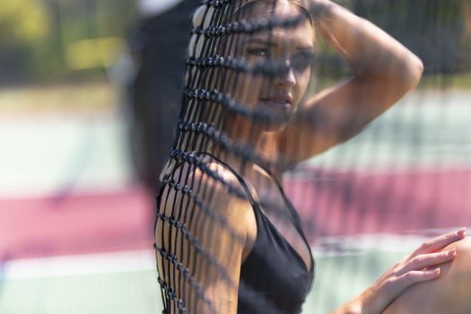 A beautiful blonde model plays tennis on a hot summers day