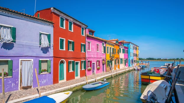 Colorful houses in downtown Burano, Venice, Italy with clear blue sky