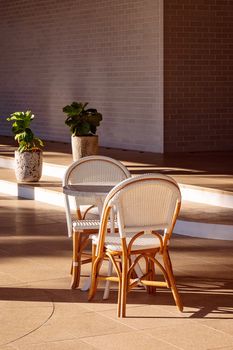 A table and chairs set up for outdoor dining in a shady spot on a hot sunny summer day