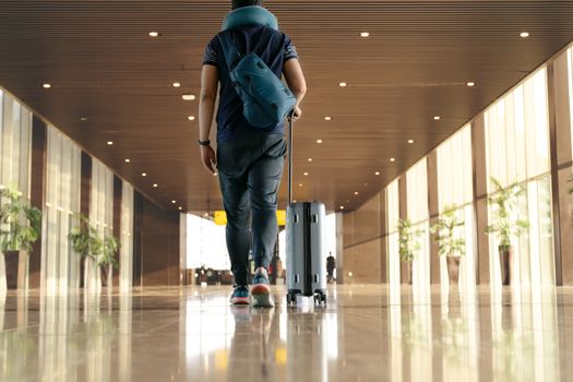 traveler with suitcase walking with carrying luggage and passenger for tour in the airport terminal for air traveling
