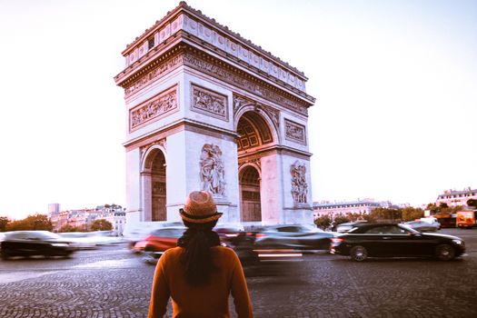 Arc de Triomphe and traveler in Paris street at night twilight