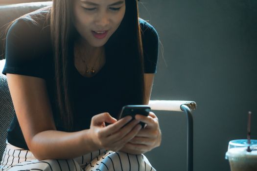 young asia woman reading message in smartphone at coffee shop