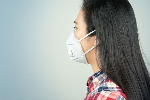 rear view of woman in mask because of air pollution and epidemic in city. Protection against virus, infection, exhaust and industrial emissions
