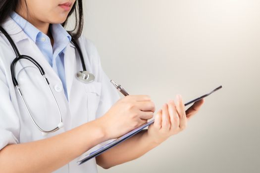 female doctor writing medical information in notebook at hospital