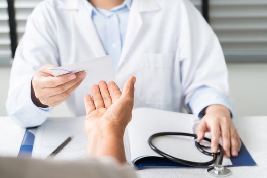 Doctor writing diagnosis and giving a medical prescription to senior women Patient
