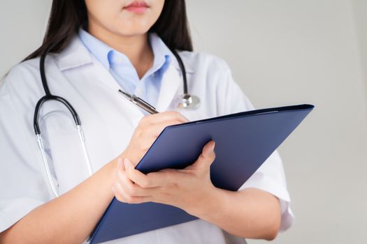 female doctor writing medical information in notebook at hospital