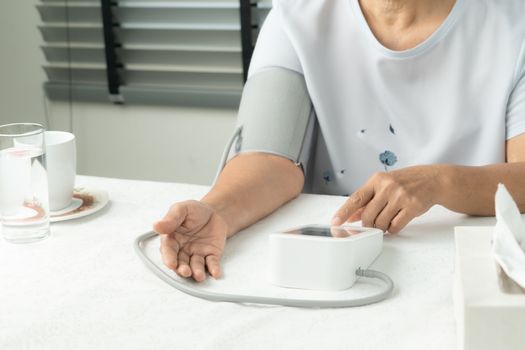 senior woman is detecting blood pressure at home