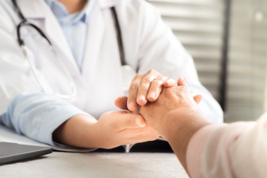 Doctor hands together holding senior woman patient