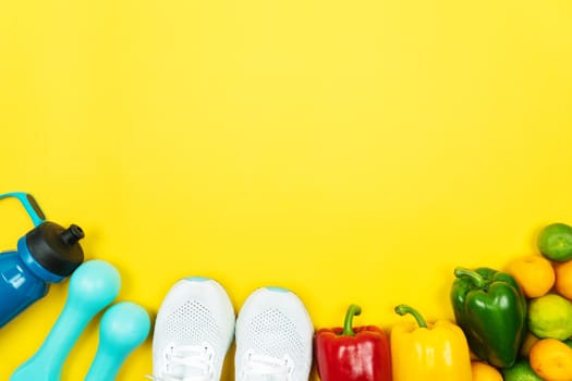 Healthy lifestyle, food and sport concept. athlete's equipment and fresh fruit and vegetable on yellow background.