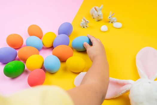 Easter day little Bunny rabbit ear with child hand and decorated eggs