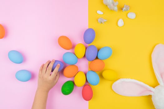 Easter day little Bunny rabbit ear with child hand and decorated eggs