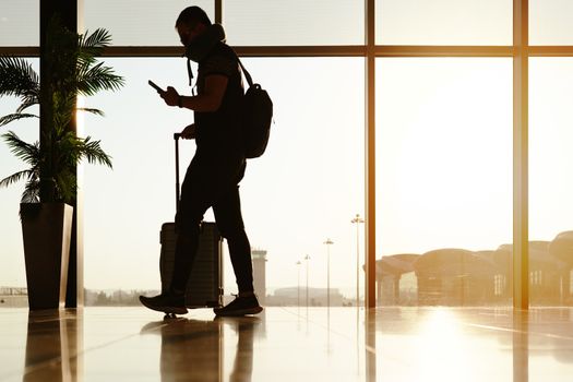 walking traveler with suitcase, passenger for tour in the airport terminal for air traveling