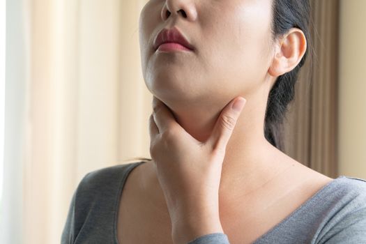 Sore Throat. Beautiful woman hand touching her pain neck. Woman healthcare concept