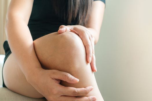 women knee painful, women touch the pain knee at home