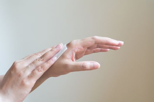 Woman cleaning her hands with white soft tissue paper. isolated on a white backgrounds