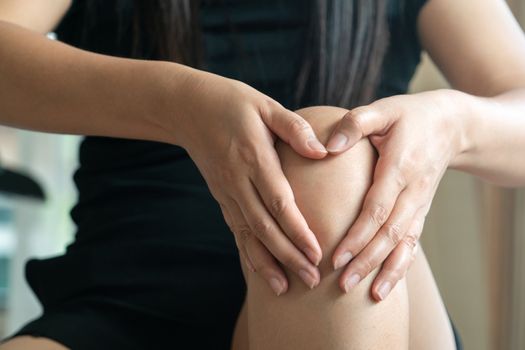 women knee painful, women touch the pain knee at home