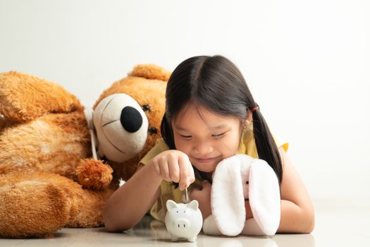 Saving and business concept, Cute girl with piggy bank and coins at home