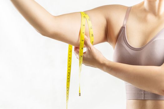 fat woman, woman hand pinching on her excessive fat arm with measure tape, woman diet lifestyle concept