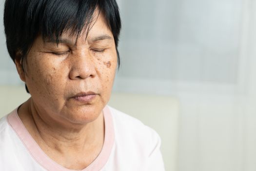 Close-up of Asian elder woman face with wrinkled skin condition