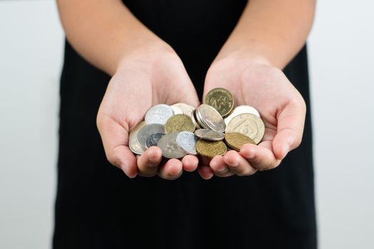 International donation concept - close up of children hands holding euro and international money coins