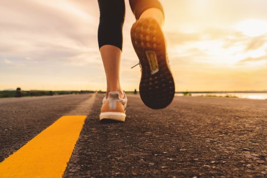 Athlete running on the road trail in sunset training for marathon and fitness. motion blur of woman exercising outdoors