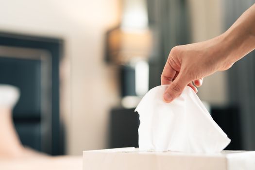 women hand picking napkin/tissue paper from the tissue box