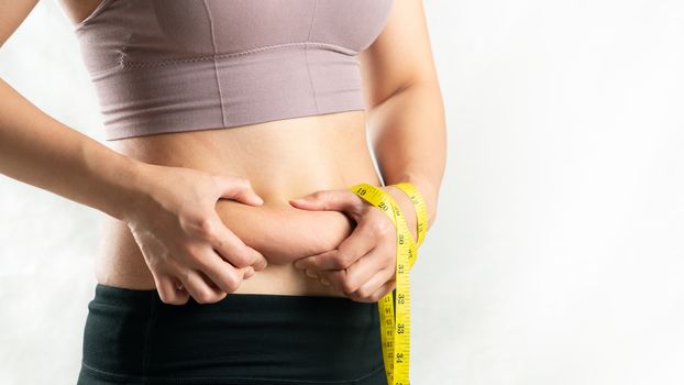 fat woman, fat belly, chubby, obese woman hand holding excessive belly fat with measure tape, woman diet lifestyle concept