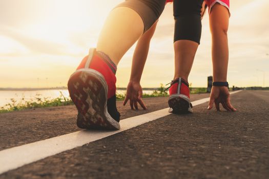 sport runner feet running on sunset lake closeup on shoe