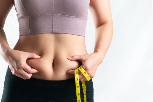 fat woman, fat belly, chubby, obese woman hand holding excessive belly fat with measure tape, woman diet lifestyle concept