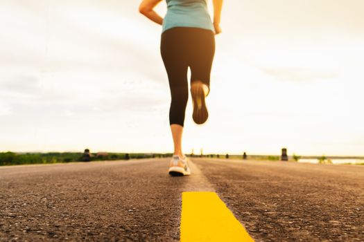 Athlete running on the road trail in sunset training for marathon and fitness. motion blur of woman exercising outdoors