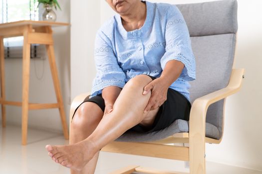 senior woman suffering from knee pain at home, health problem concept