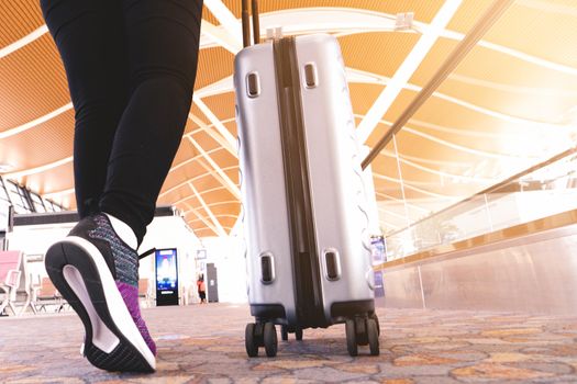 traveler with travel bag or luggage walking in the airport terminal walkway for air traveling