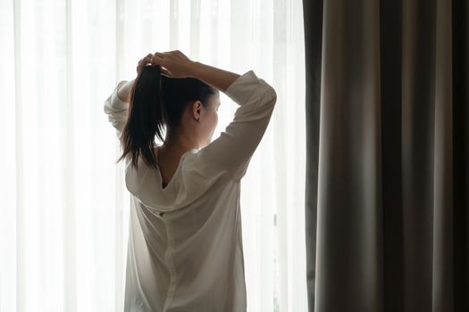 rear view of women tightening the hair in a ponytail