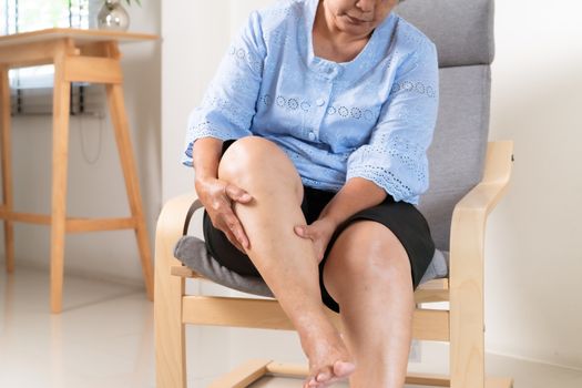 senior woman suffering from knee pain at home, health problem concept