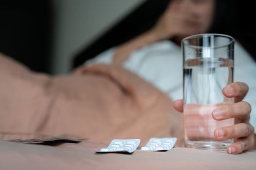 medicine with sick women hand hold a glass of water, healthcare and medicine recovery concept - soft focus