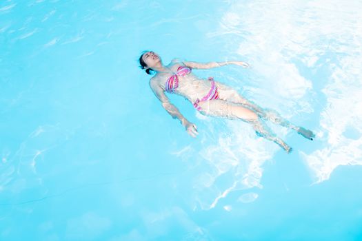 Beautiful Asia woman enjoy swimming in the pool