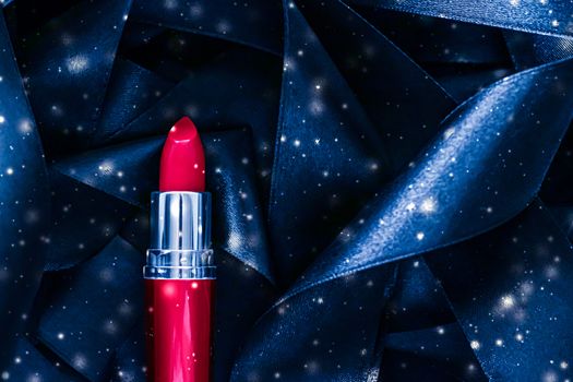 Red lipstick on blue silk and shiny glitter background, luxury make-up and beauty cosmetics