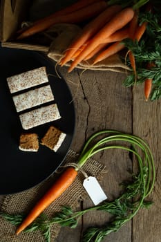 Fresh organic carrots, carrots English cakes in a box with canvas on antique wooden table. Rustic kitchen concept. Banner, poster, mock up. Grunge, vintage, rustic style