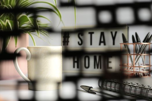 Home office desc concept during self quarantine as preventive measure against virus. Stay safe concept. Cup of coffee, clock, stationary, home plant on white background viie via soft focus net
