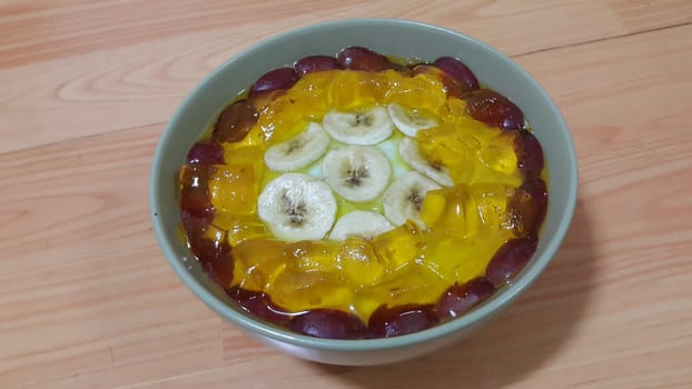 Creamy tasty sweet custard with banana pieces layered on surface on wooden floor. A top view of home made custard, a dairy products for dessert after meal.
