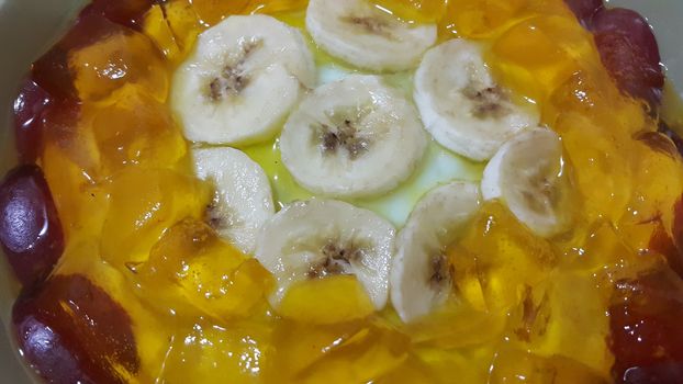 Creamy tasty sweet custard with banana pieces layered on surface. A close up tope view of home made custard, a dairy products for dessert after meal.