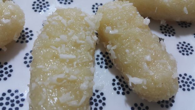 Traditional home made sweets cham cham or chum chum (selective focus ) served in a white ceramic plate