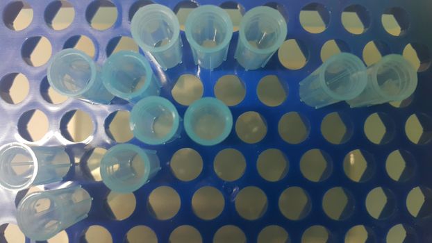 Close up view of blue micro litre tips in microtip box with empty holes. Reseach lab. tool for accurate measurement.