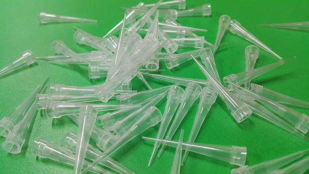 Close up view of micro litre tips on green floor sheet with empty holes. Reseach lab. tool for accurate measurement.