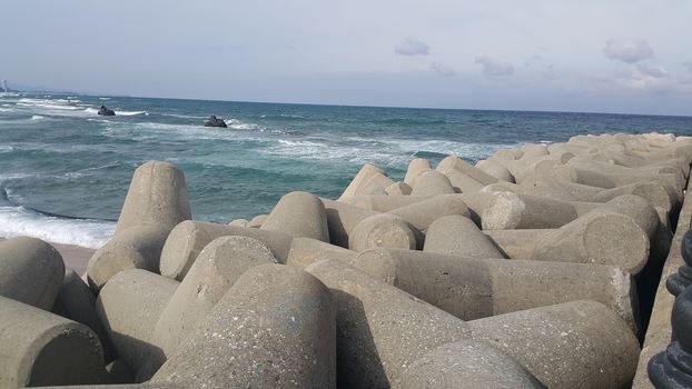 Close view of tetrapod stones on the sea shore to prevent coastal ersosion. Break water concrete tetrapods.