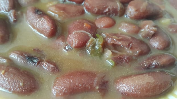 Kidney beans dish:  Closeup view of cooked red kidney beans dish. Dark red useful beans dish background.
