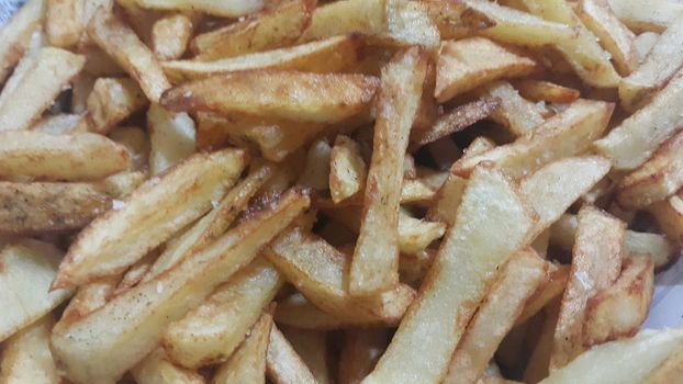 Closeup view of potato french fries or roasted potato sticks  with copy space for text